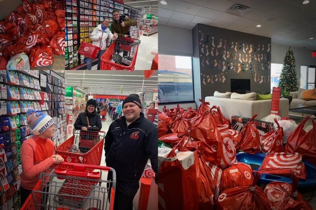 Volunteers with shopping carts full of red gift bags helping families during community giving event at store.
