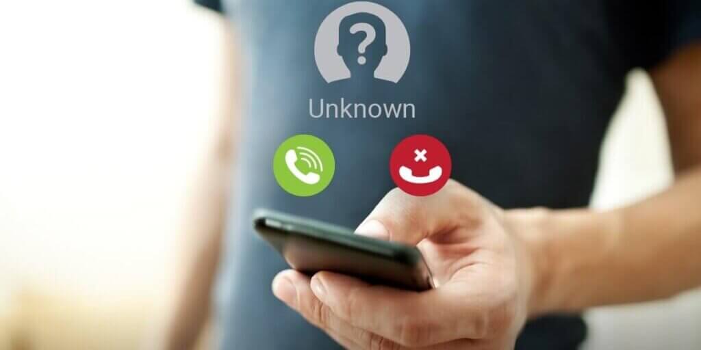 Hand holding phone with "Unknown" caller ID and green answer or red decline call buttons displayed.